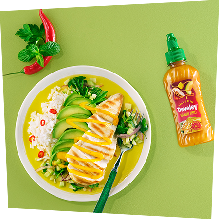 Ein Teller mit gelben Curry mit saftigem Hähnchen, Avocado und Reis, getoppt von der Sauce & Style Mango Chili Sauce von Develey