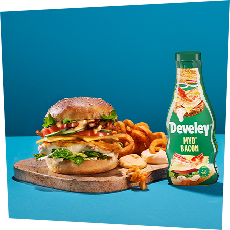 Ein großer Burger mit Curly Fries und der MYO® Bacon von Develey als Dip