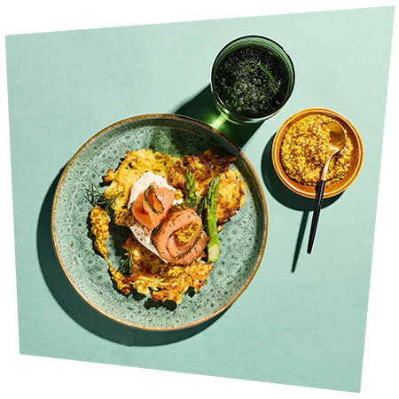 Ein Teller mit herzhaften Reibekuchen mit Frischkäse und Lachs und dem Senf-Kaviar von Develey als Topping